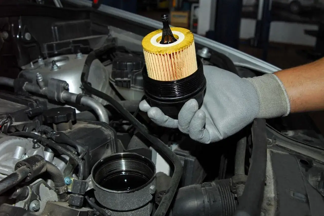 Maintenant, vous comprenez ce qu'est la vidange voiture : un filtre &agrave; huile jaune est retir&eacute; du moteur.
