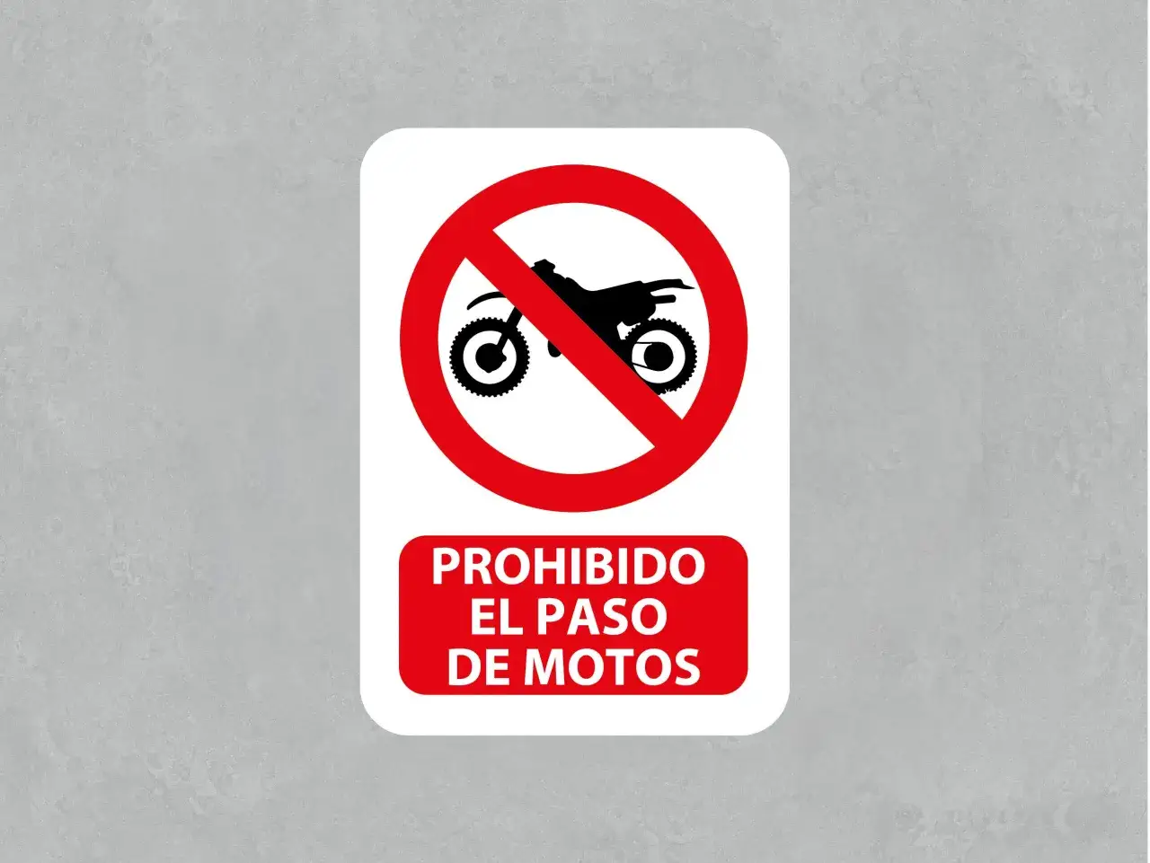 Señal de prohibición de paso para motos. Un círculo rojo con una línea diagonal roja atraviesa la silueta negra de una motocicleta. Debajo, un recuadro rojo dice 