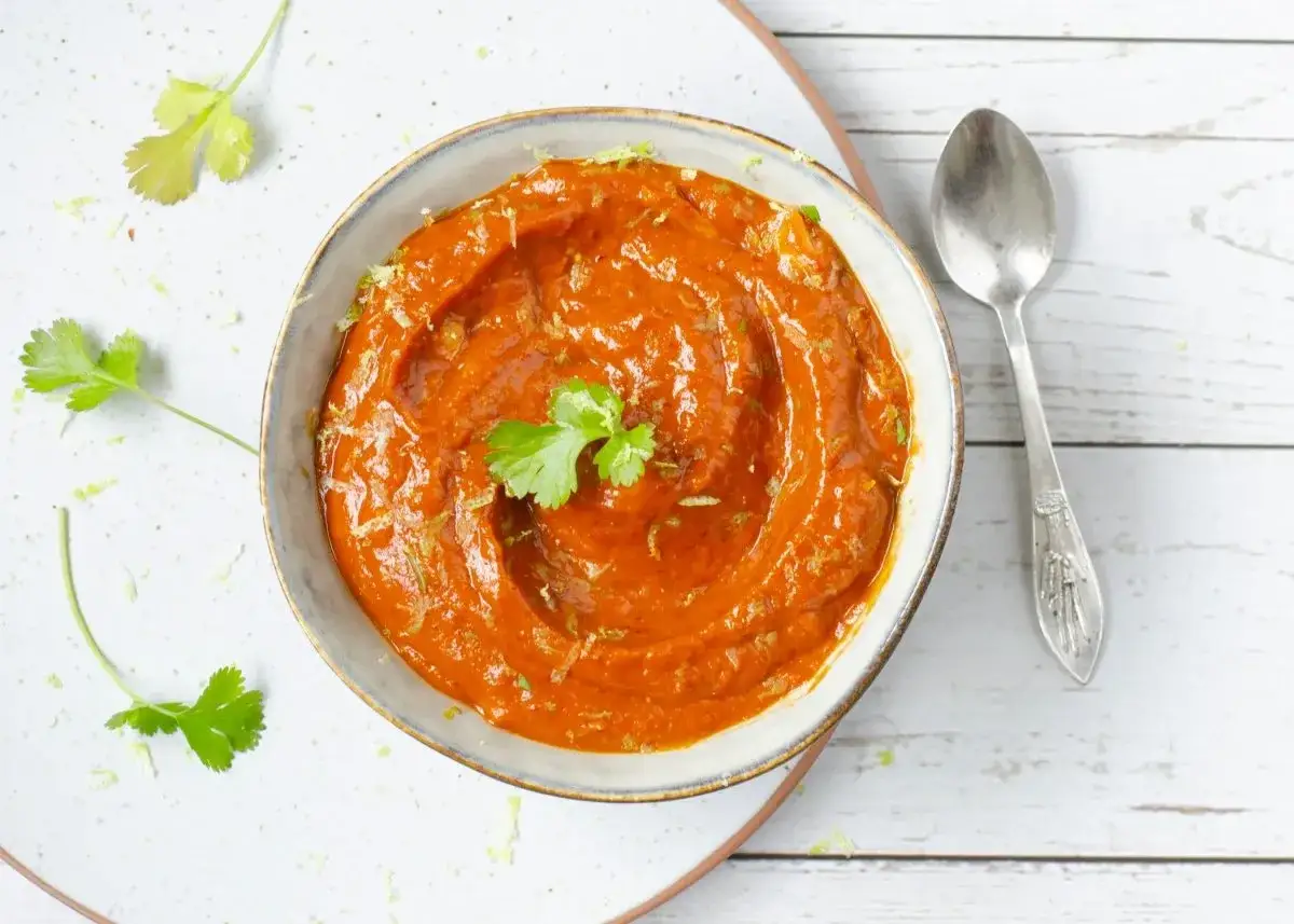 Un taz&oacute;n de cremosa salsa chipotle, adornado con cilantro fresco y ralladura de lima, listo para acompa&ntilde;ar tus platillos.
