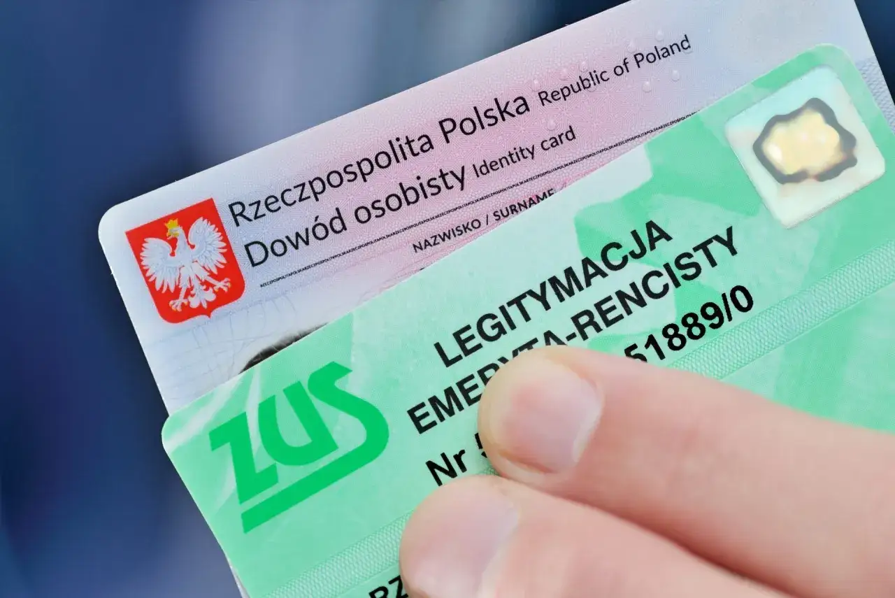 Palec trzyma legitymację ZUS, która potwierdza uprawnienia rencisty. Dowód osobisty leży pod nią.