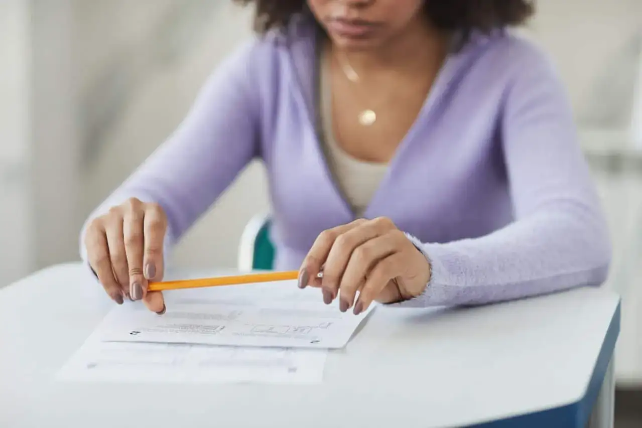 Estudiante concentrada, l&aacute;piz en mano, prepar&aacute;ndose para como estudiar para un examen de desarrollo.