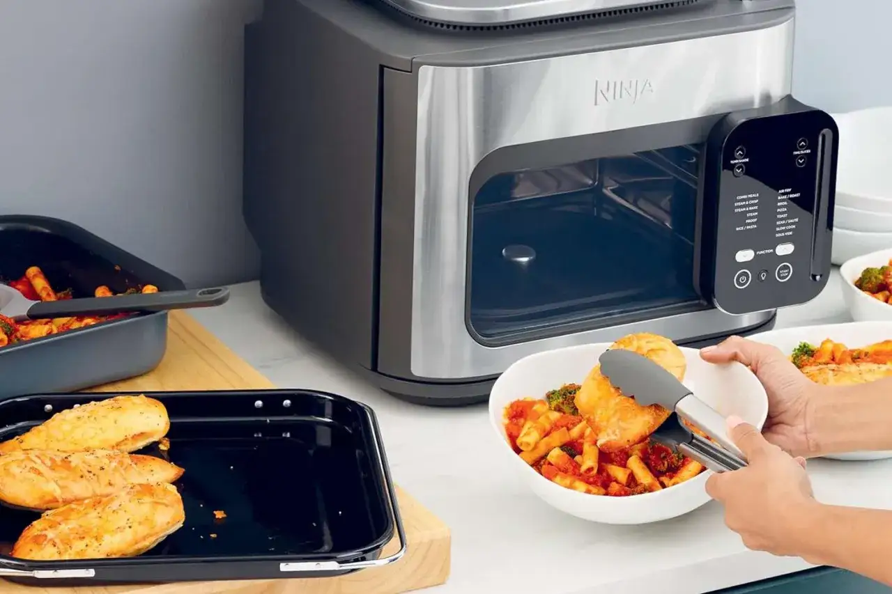 Ninja to firma, która oferuje wielofunkcyjne urządzenia kuchenne, takie jak ten piekarnik z funkcją air fryer. Na zdjęciu widać gotowe dania.