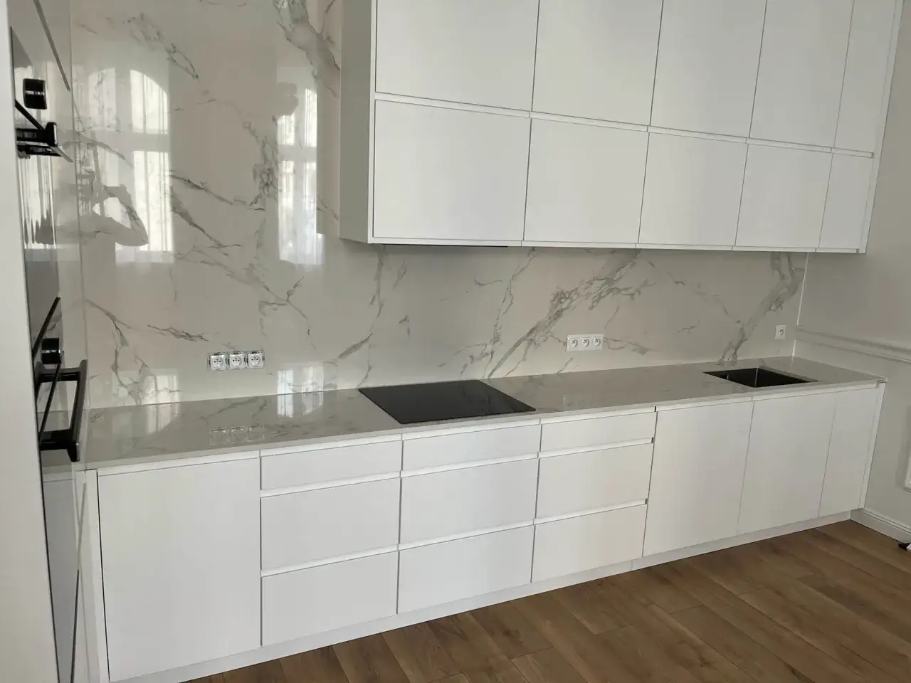 Nowoczesna kuchnia z białymi frontami i blatem z Dektonu. Sprawdź, jaka jest dekton cena za m2 dla tego eleganckiego wykończenia.
