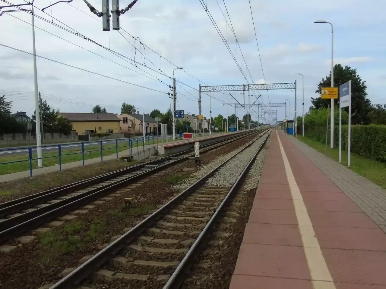 Stacja kolejowa w Blachowni, z widocznymi torami, peronem i tablicą informacyjną. Sprawdzam częstochowa - blachownia rozkład jazdy.
