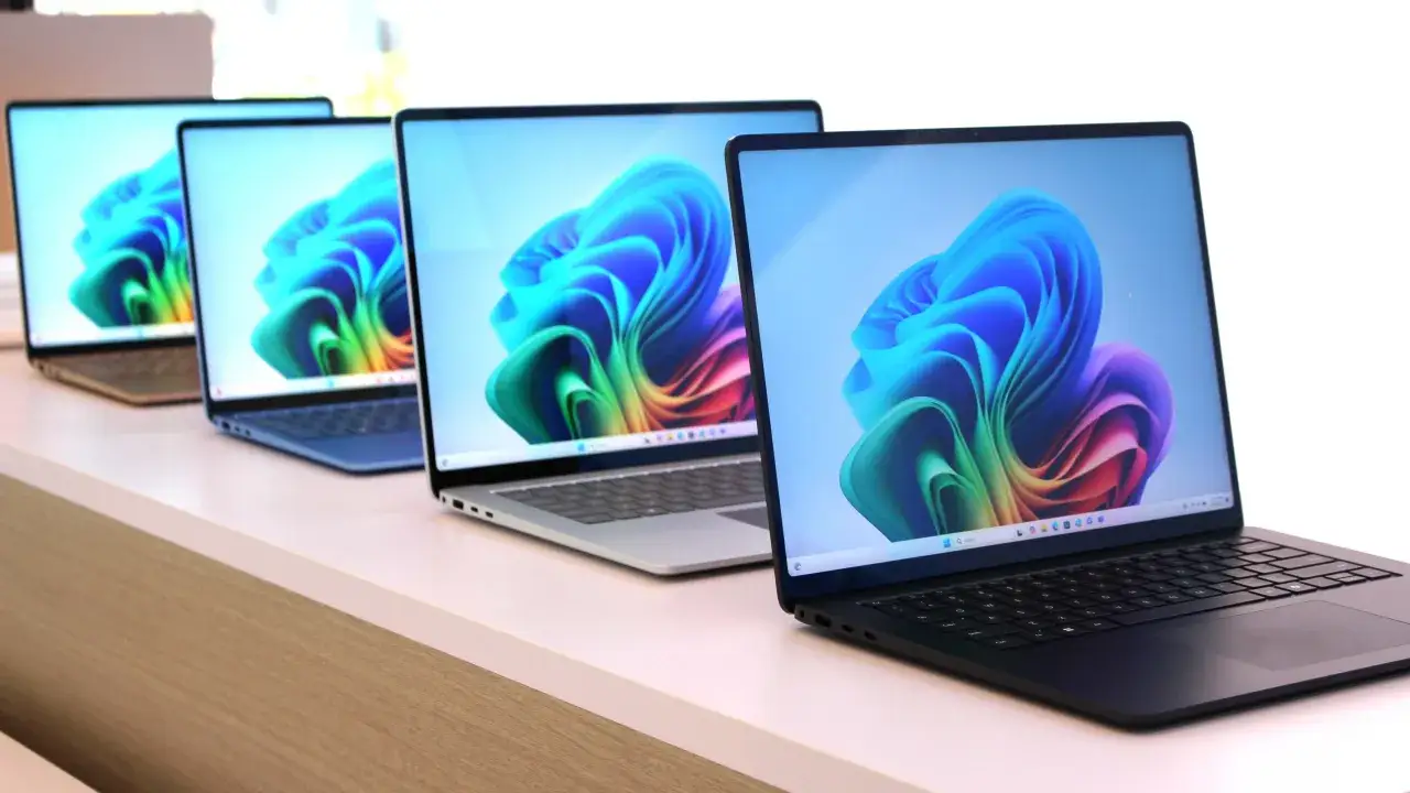 Rząd laptopów z kolorową tapetą Windows 11 ARM.