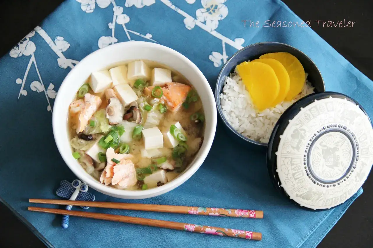 Herzhafte Miso-Suppe mit Lachs, Tofu und Fr&uuml;hlingszwiebeln, serviert mit Reis und eingelegtem Rettich. Perfekt f&uuml;r Miso Paste Rezepte.
