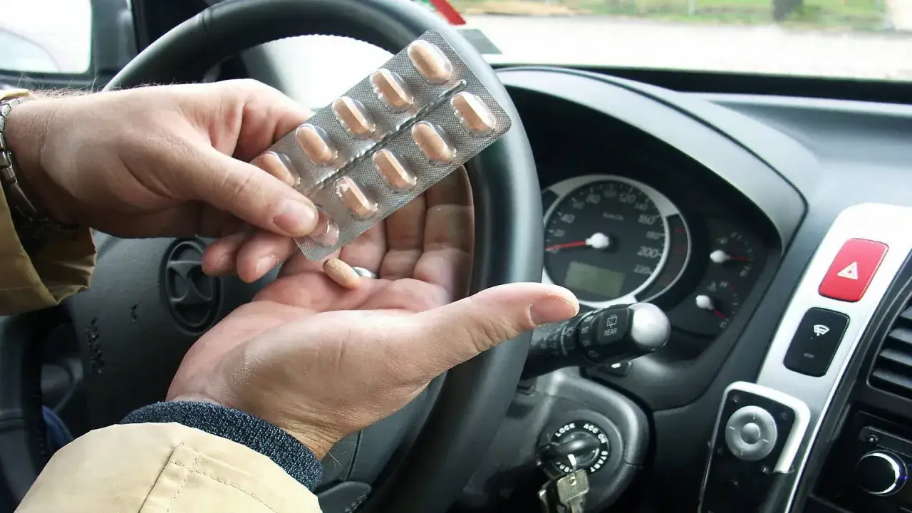 Mann nimmt Medikamente im Auto ein, bevor er mit dem Tavor autofahren beginnt.