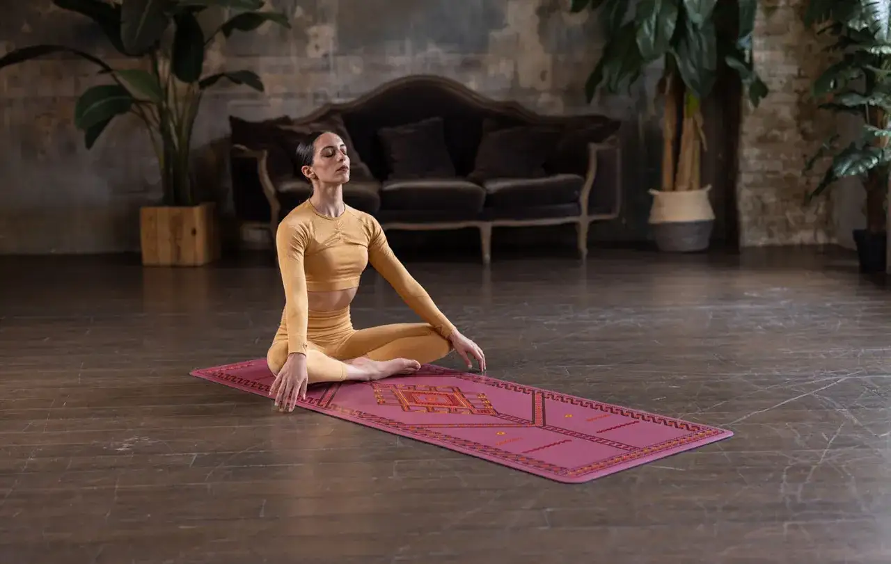 Mujer meditando en postura de loto sobre una esterilla, disfrutando de los savasana beneficios.