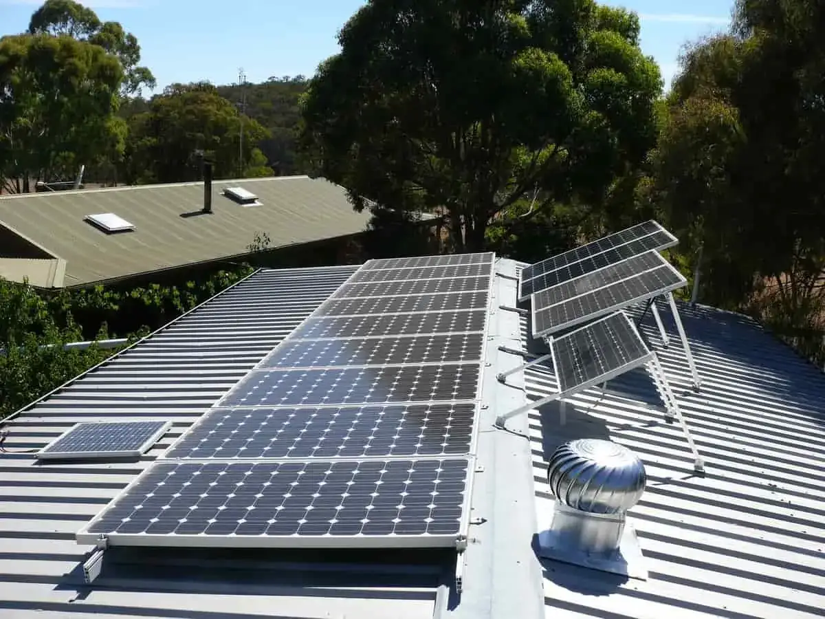 Panneaux solaires sur un toit, prêts pour le calcul de production. Un petit panneau est visible à gauche, et un aérateur rotatif est à droite.