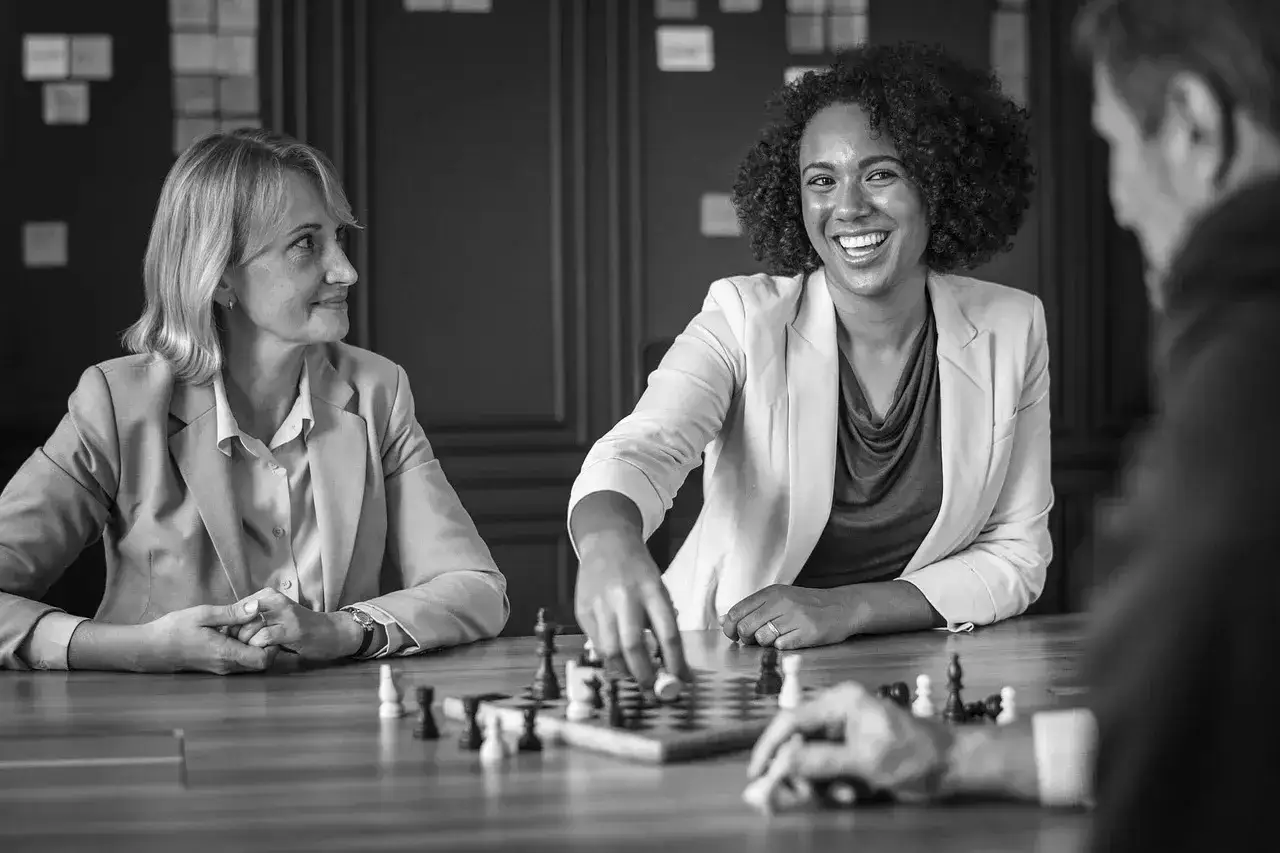 Kvinnor och m&auml;n spelar schack, en strategisk aktivitet som kan liknas vid **UGL utbildning** f&ouml;r att utveckla ledarskap.