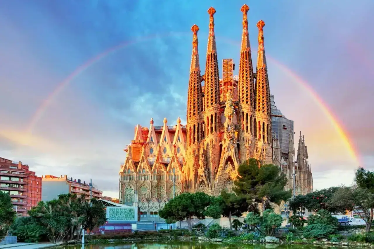 La Sagrada Familia, uno dei monumenti famosi nel mondo, brilla sotto un arcobaleno dopo la pioggia.