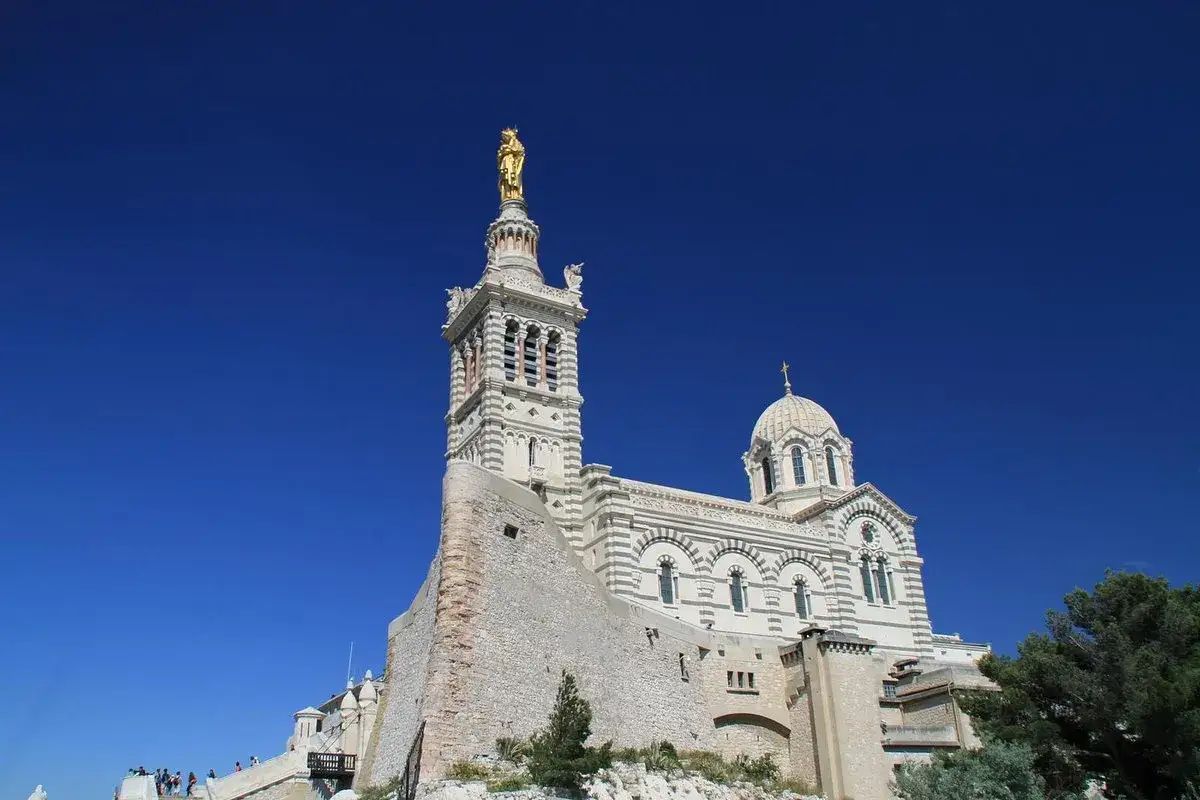 Basilica di Notre-Dame de la Garde, simbolo di cosa vedere a Marsiglia in un giorno, domina la città sotto un cielo azzurro.