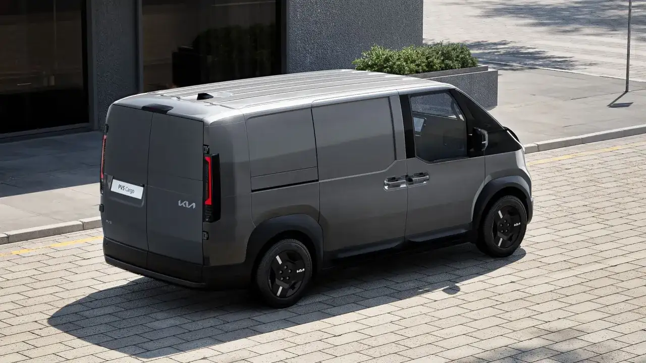 Szary van Kia PV5 Cargo stoi na chodniku z kostki brukowej. Nowoczesny design, idealny do transportu.
