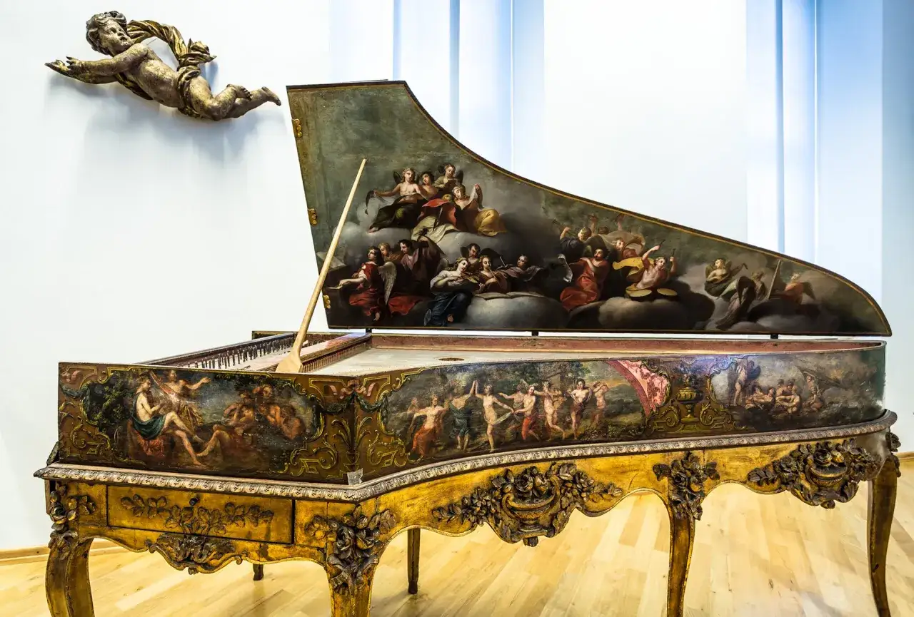 Ein prachtvolles Cembalo, verziert mit Malereien, die an die Zeit von Johann Sebastian Bach erinnern. Engel und musizierende Figuren schmücken die Instrumente.