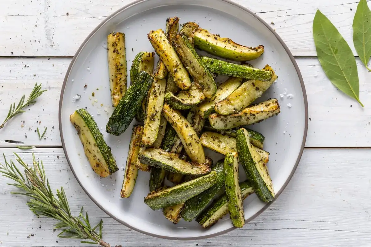 Zucchine in friggitrice ad aria con pangrattato, croccanti e dorate, condite con erbe aromatiche.