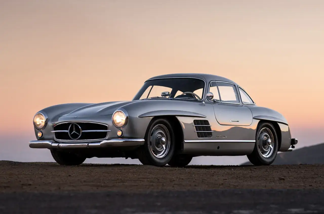 Srebrny Mercedes 300 SL Gullwing na tle zachodzącego słońca. Ikona motoryzacji.