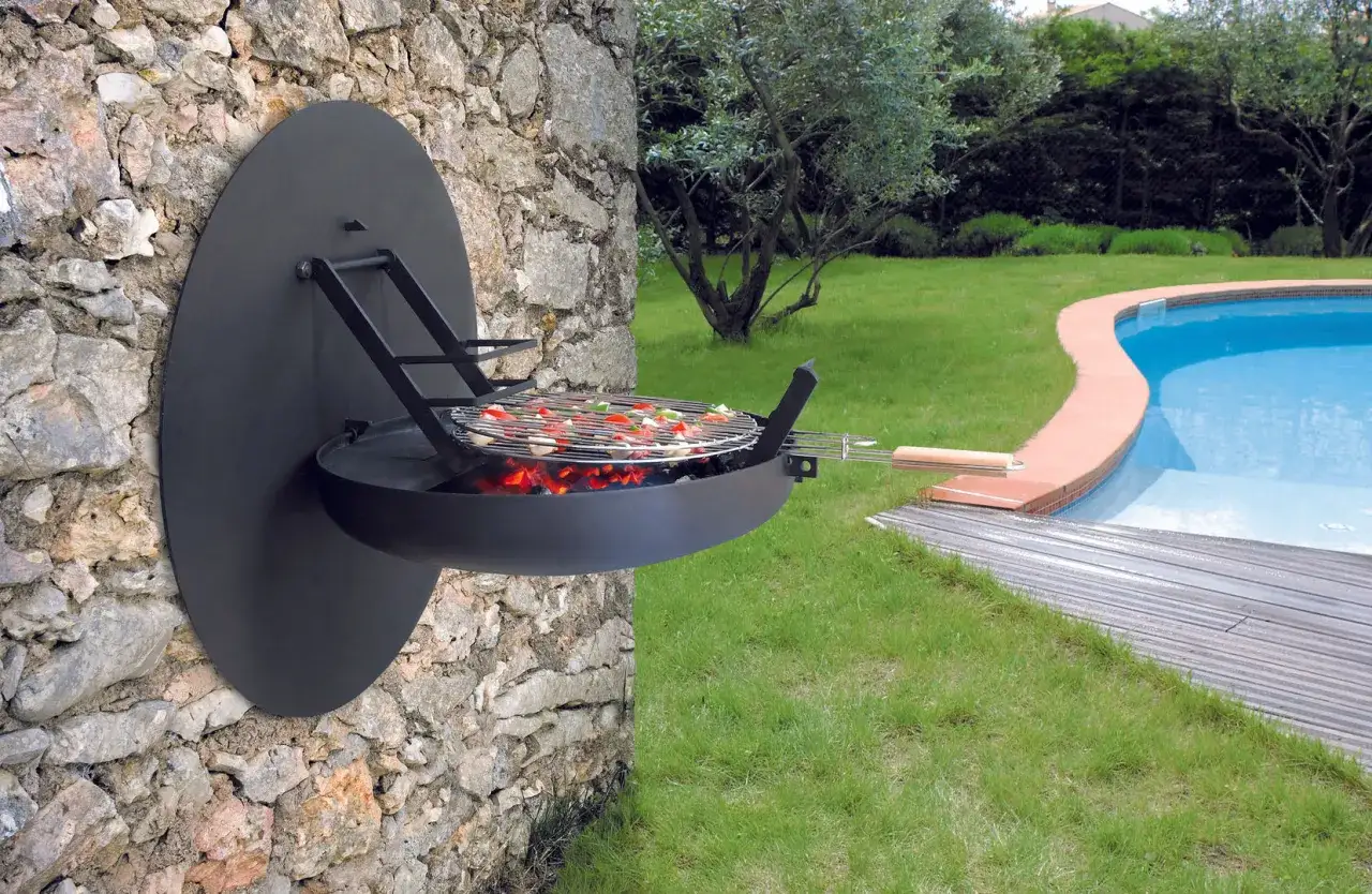 Una moderna zona barbecue a parete, con griglia piena di verdure e brace ardente, accanto a una piscina scintillante.
