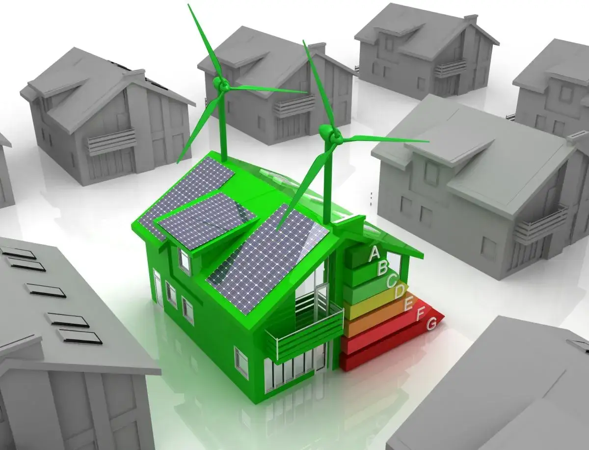 Casa verde con pannelli solari e turbine eoliche, circondata da edifici nzeb grigi. Scala di efficienza energetica da A a G.