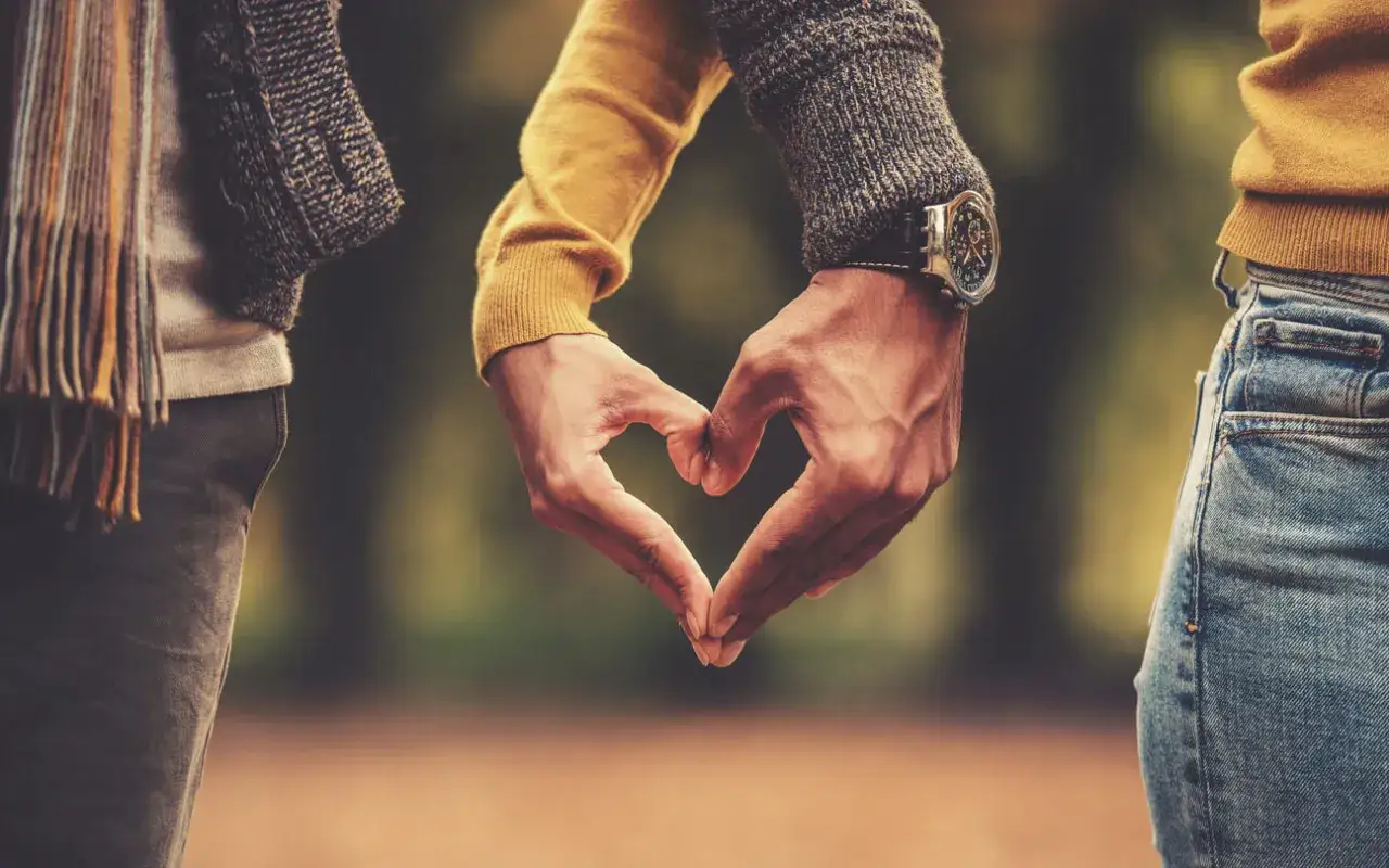 Manos entrelazadas formando un corazón, un gesto que habla de los lenguajes del amor.