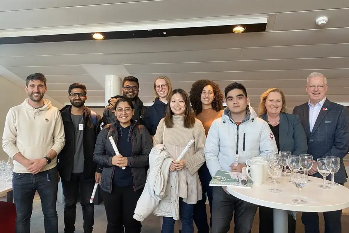 A diverse group celebrates completing their organizational management degree.