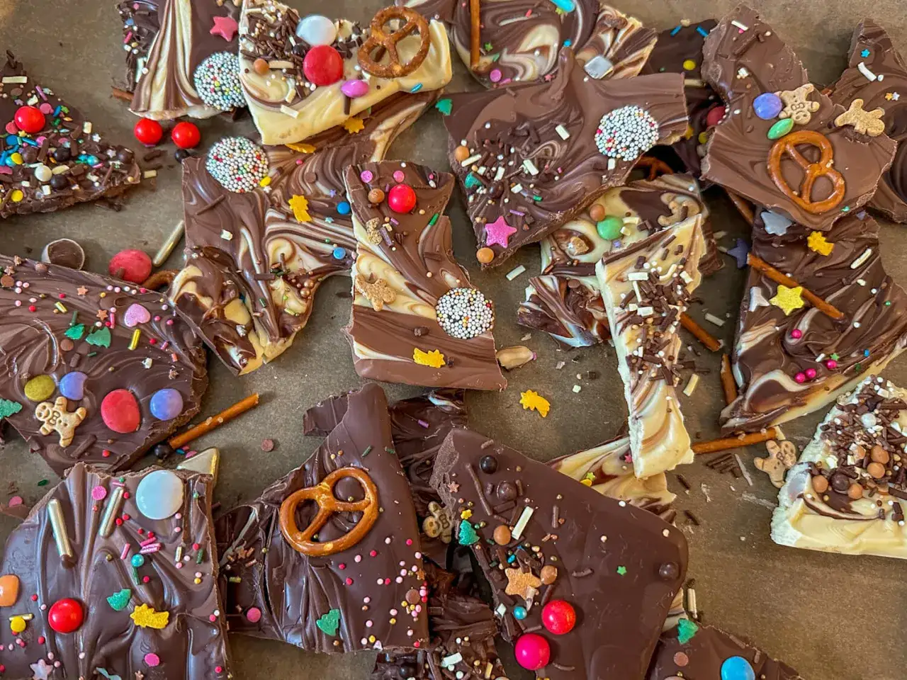 Bruchschokolade selber machen: Bunte Schokoladenstücke mit Streuseln, Smarties, Lebkuchenmännchen und Salzstangen.
