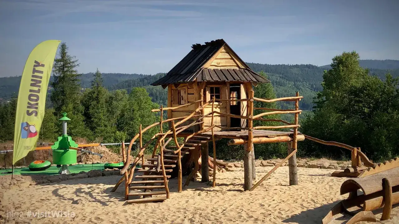 Drewniany domek na drzewie i plac zabaw to wspaniałe atrakcje dla dzieci w Wiśle. Idealne miejsce na letnie zabawy.