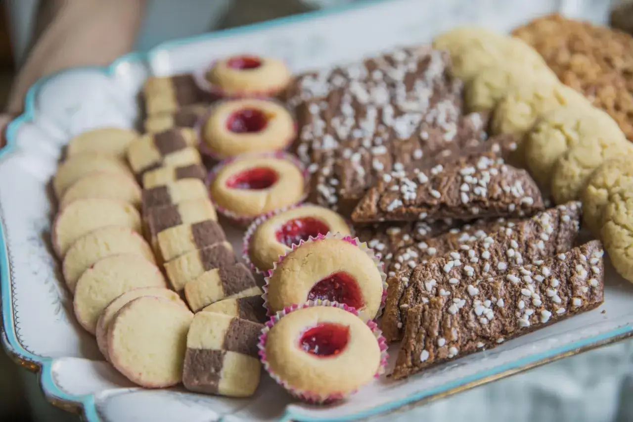 En bricka full med hembakade småkakor, perfekta för fika. Här finns hallongrottor, drömmar och chokladkakor med pärlsocker. Ett härligt fika recept!