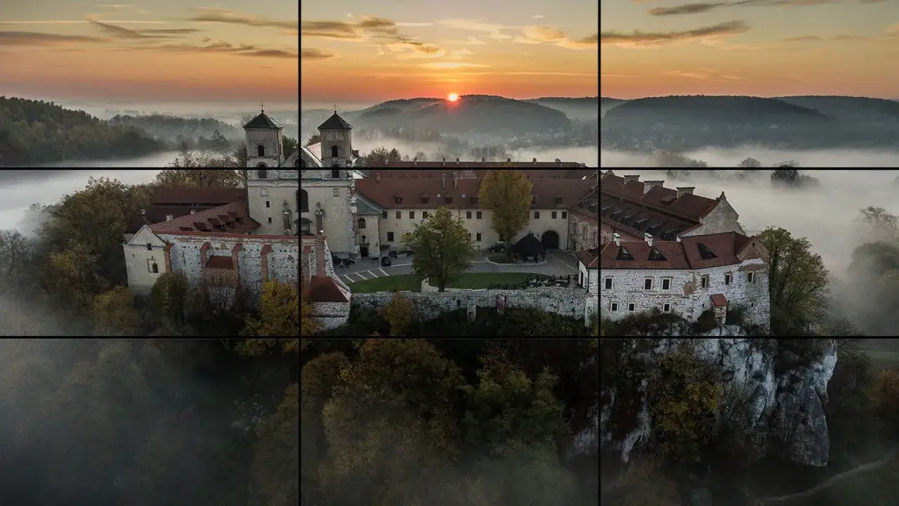Wschód słońca nad mglistą doliną, malowniczy klasztor na skale. Niezwykła fotografia krajobrazowa.
