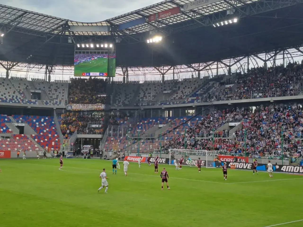 Mecz Górnik Zabrze – Korona Kielce na stadionie. Piłkarze na murawie, trybuny wypełnione kibicami. Wynik 0:0 w 71. minucie.