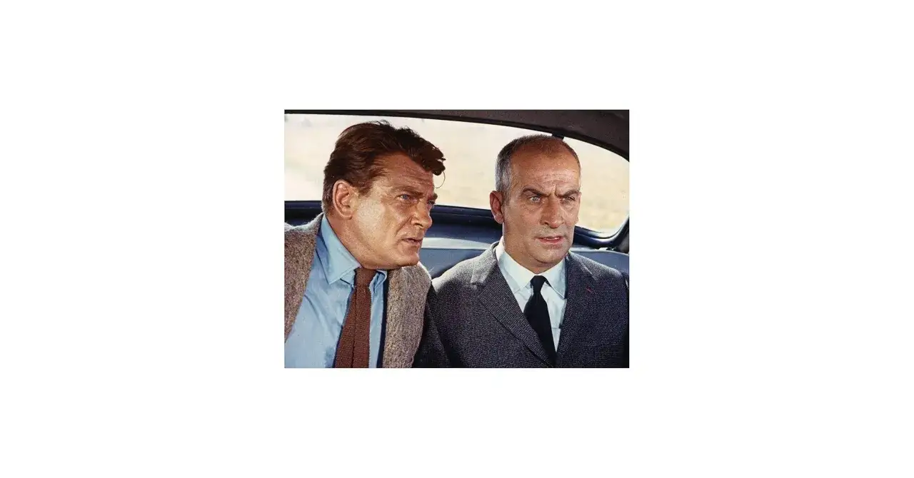 Dwóch mężczyzn w samochodzie, jeden z nich przypomina aktora z filmów Louisa de Funès.