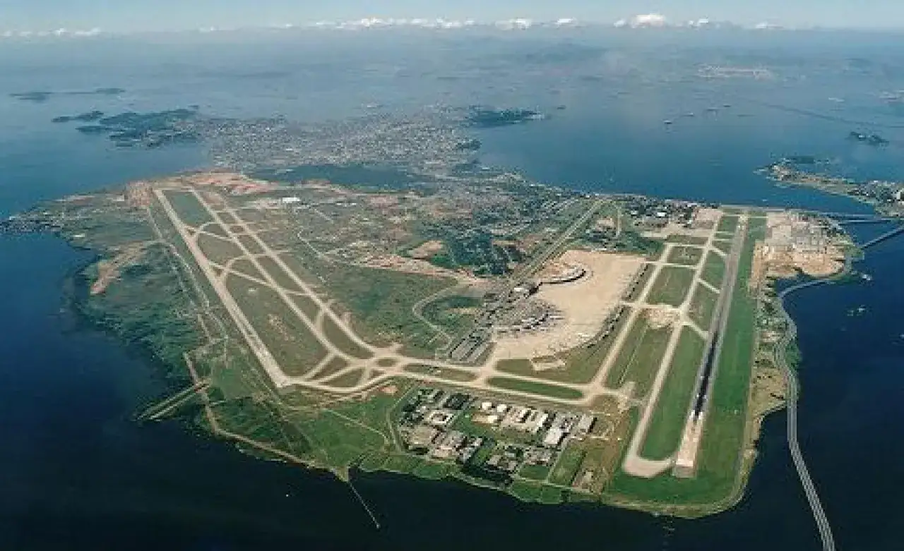 Lotnisko Rio de Janeiro z lotu ptaka, z pasami startowymi i terminalem, otoczone wodą i zielenią.