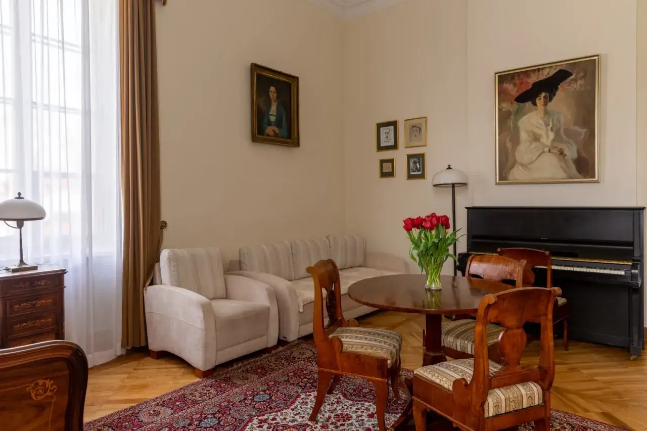 Elegancki salon z fortepianem i portretami. Sprawdź pałac Radziejowice noclegi cennik i poczuj atmosferę dawnych lat.
