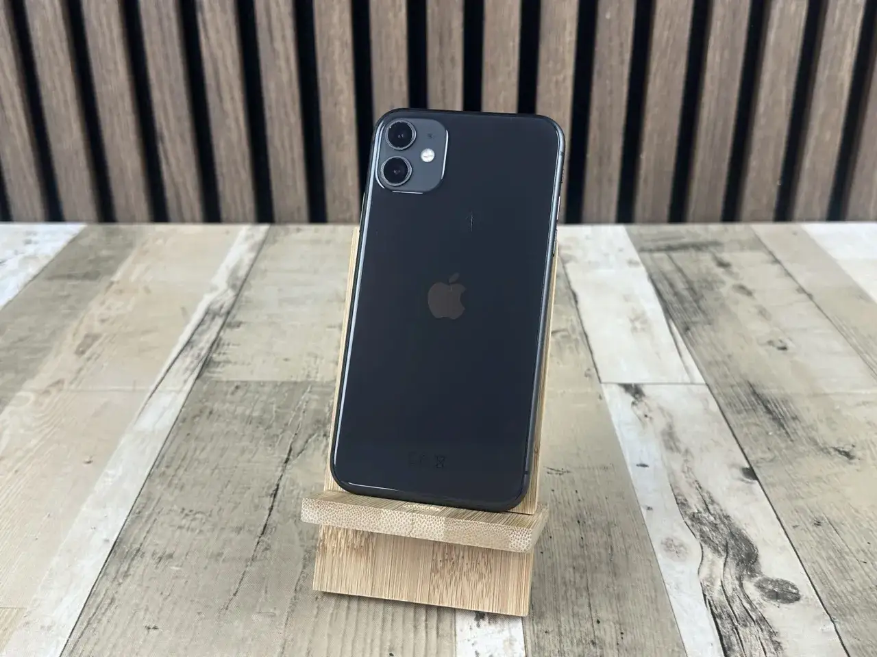 Elegancki iPhone 11 czarny na drewnianym stojaku, gotowy do działania.