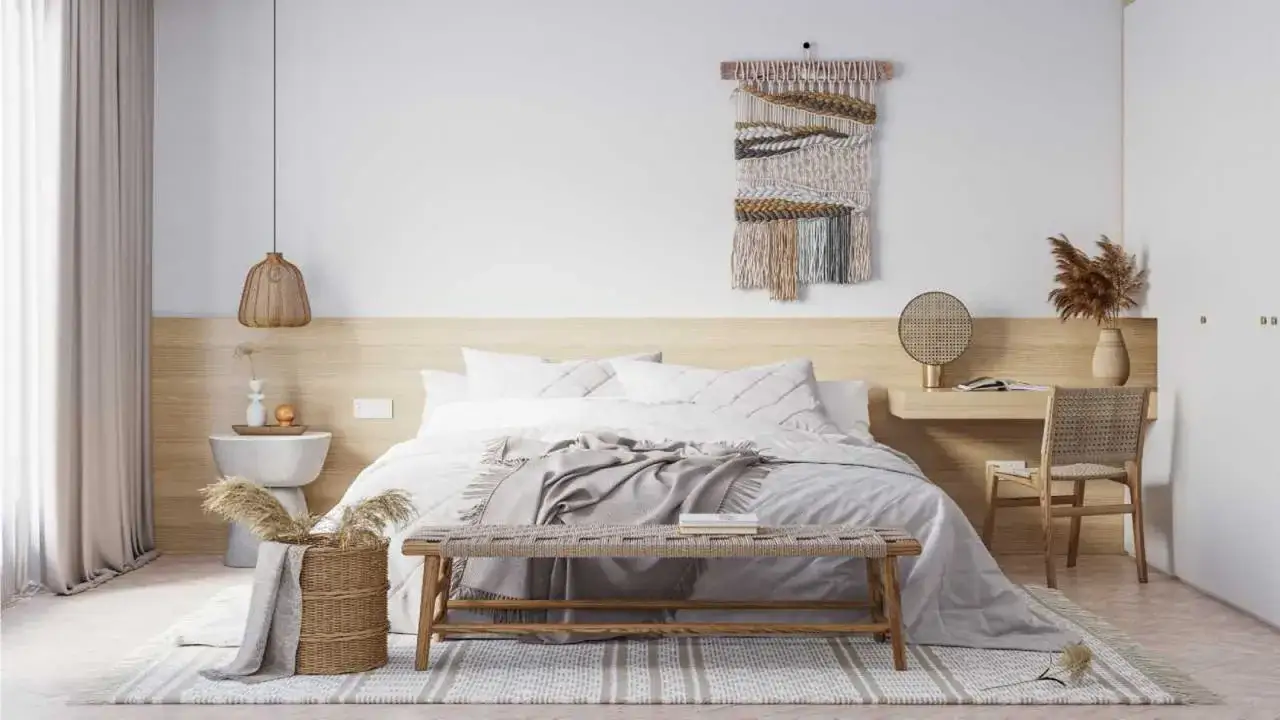 Habitación serena con cama blanca, banco de madera y lámparas de techo sin punto de luz, creando un ambiente acogedor.