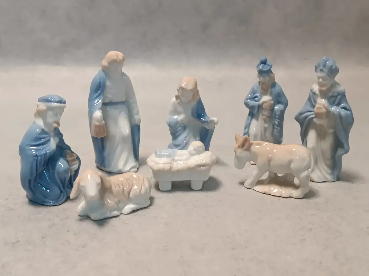 Figurki szopki bożonarodzeniowej: Maryja, Józef, Dzieciątko Jezus w żłóbku, owieczka, osiołek i trzej królowie. Narodził się nam zbawiciel tekst.