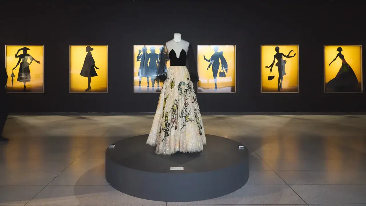 Eugenio Recuenco's exhibition features a striking gown on display, surrounded by framed silhouettes of women in elegant poses.