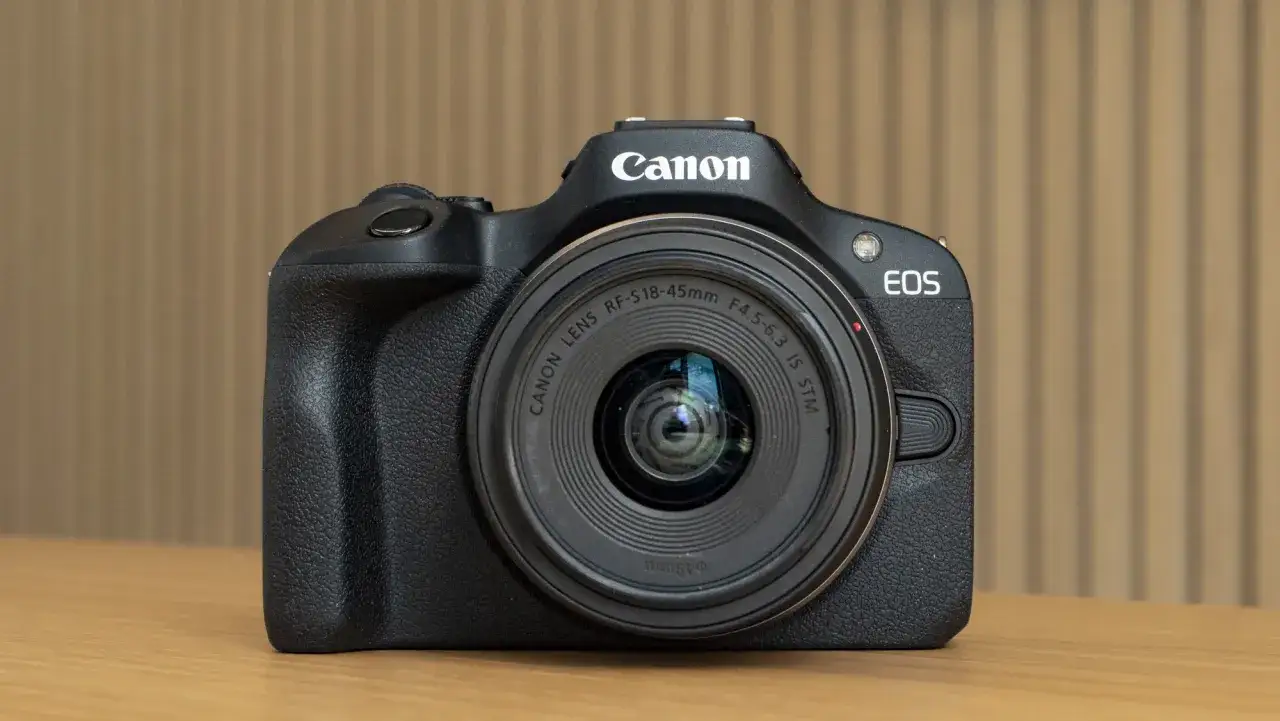 Czarny aparat Canon EOS z obiektywem RF-S18-45mm, idealny aparat dla amatora chcącego zacząć przygodę z fotografią.