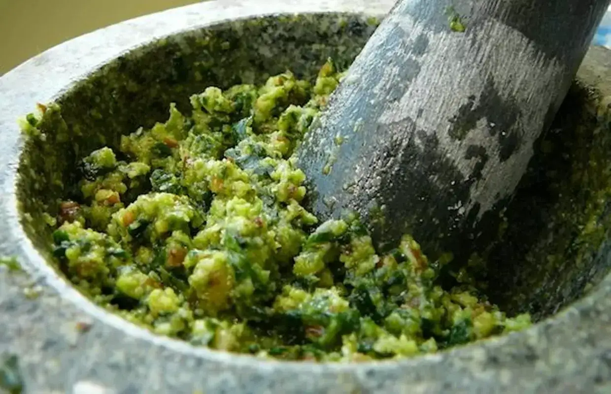 Pilon et mortier remplis d'un pesto ail des ours frais et vibrant, pr&ecirc;t &agrave; &ecirc;tre d&eacute;gust&eacute;.