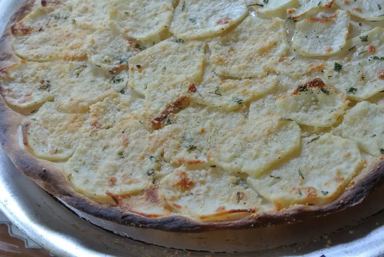Eine köstliche Pizza Bianca mit dünnen Kartoffelscheiben und Kräutern, perfekt für ein einfaches pizza bianca rezept.