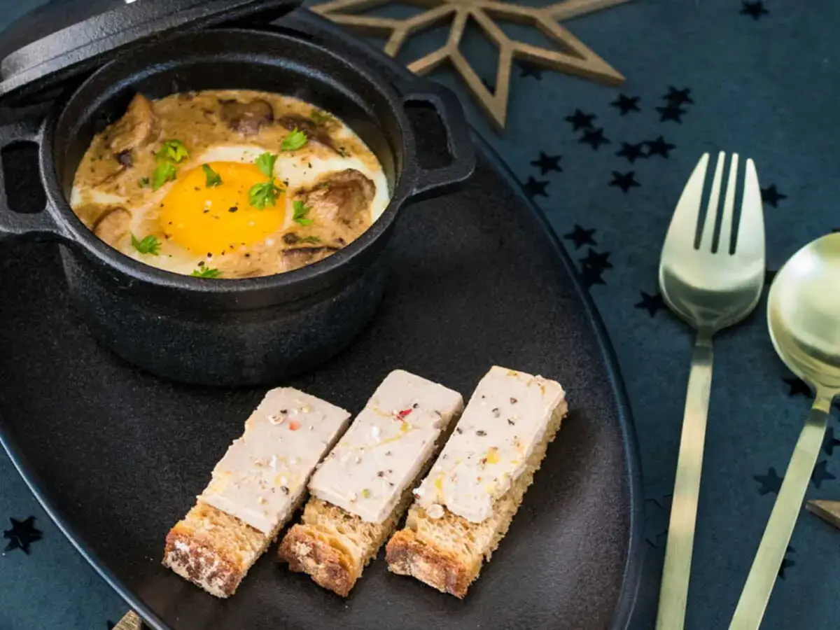 Œuf cocotte aux champignons et foie gras, servi avec des toasts. Une recette gourmande pour les fêtes.