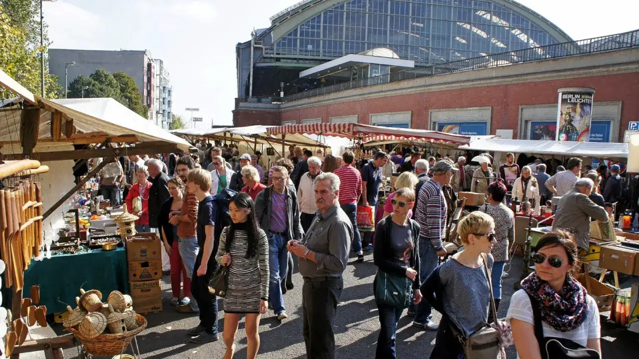 Menschenmassen auf einem belebten Flohmarkt am 1. Mai, mit vielen Ständen, die Antiquitäten und Kuriositäten anbieten.