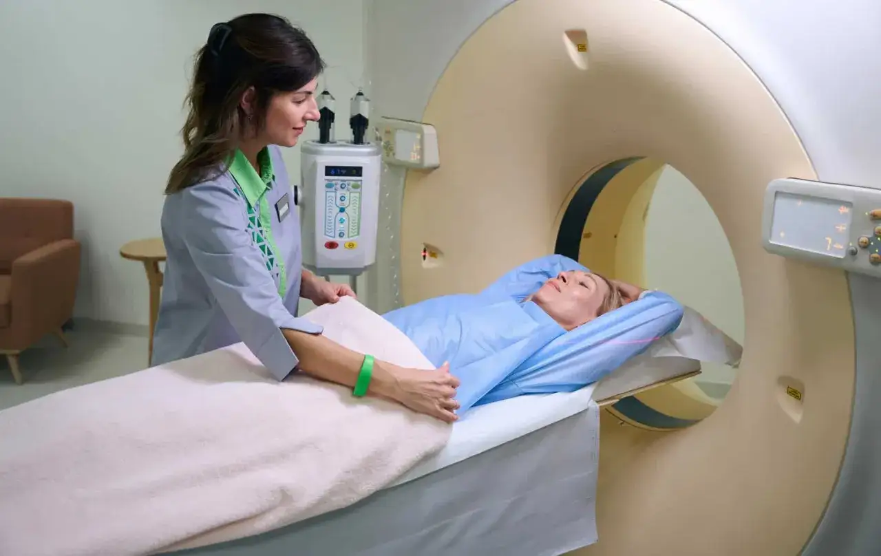 Ärztin bereitet Patientin für CT-Scan vor, um ein gutartiges Lymphom auszuschließen.