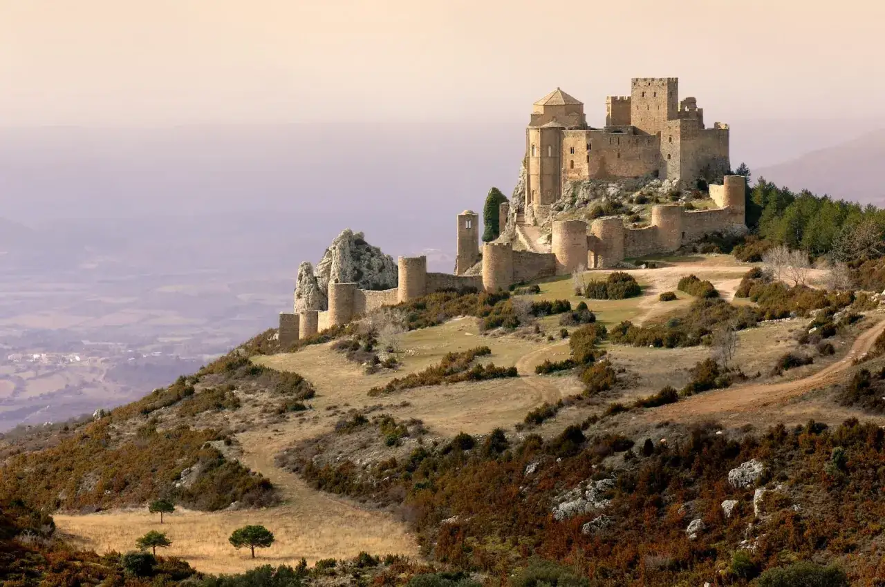 Majest&auml;tisches Castillo de Loarre thront auf einem H&uuml;gel, umgeben von einer weiten Landschaft.