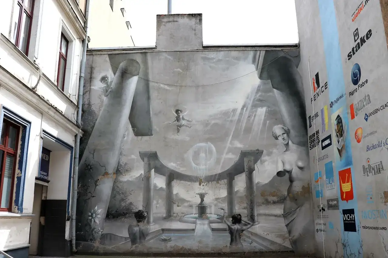 Fasada z surrealistycznym muralem, aniołkiem i rzeźbami. Idealne miejsce, by zobaczyć, co zwiedzić w Łodzi.