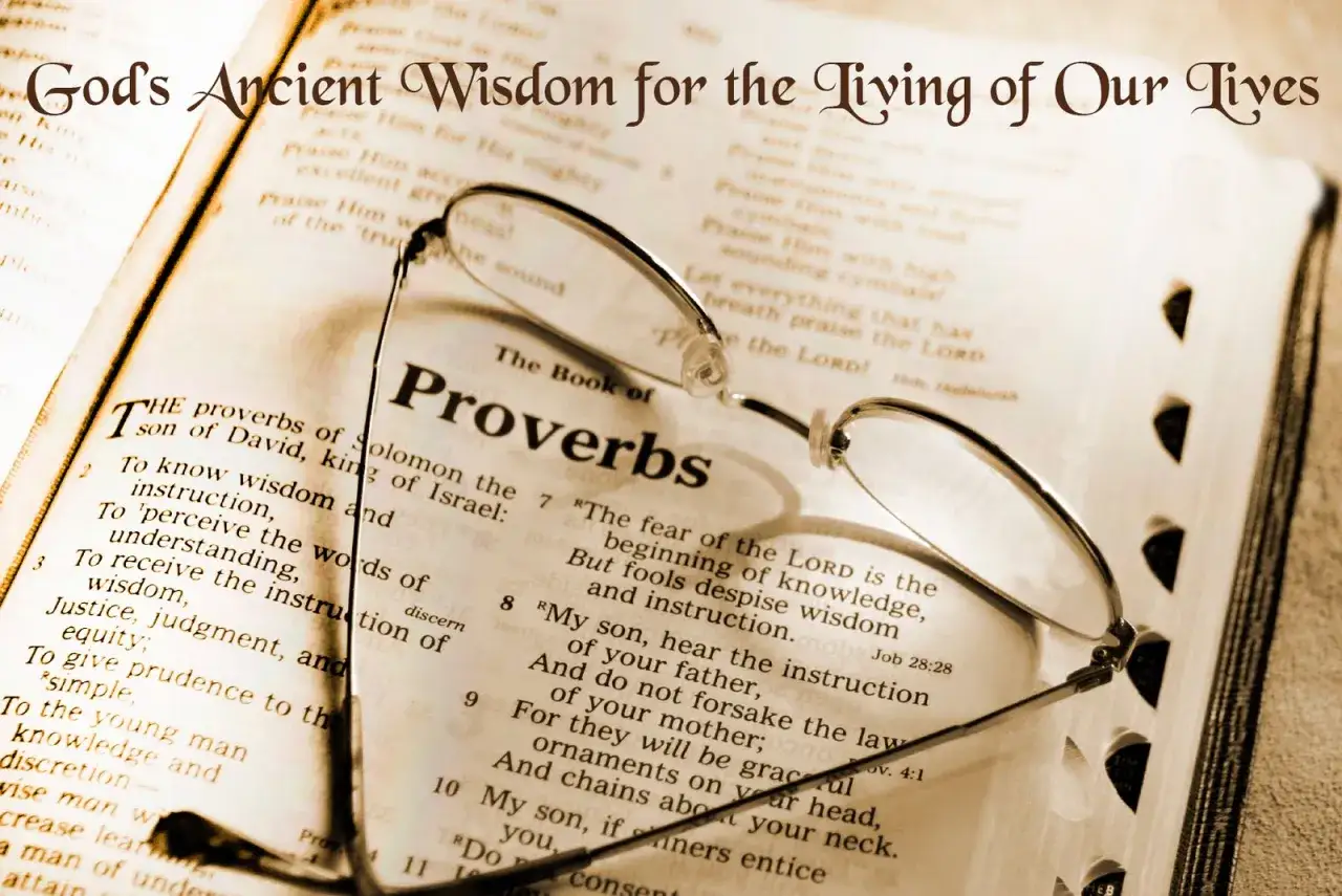 Glasses rest on an open Bible, the Book of Proverbs, symbolizing the search for wisdom and understanding in God's ancient word.
