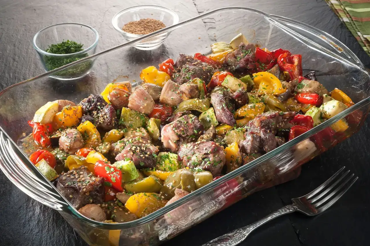 Sabroso redondo de ternera asado con pimientos de colores, calabacín y especias, listo para servir.