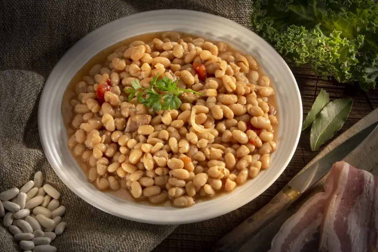 Un plat de haricots blancs mijotés, garni de persil. Le haricot blanc bienfait est un aliment sain et nourrissant, parfait pour un repas réconfortant.