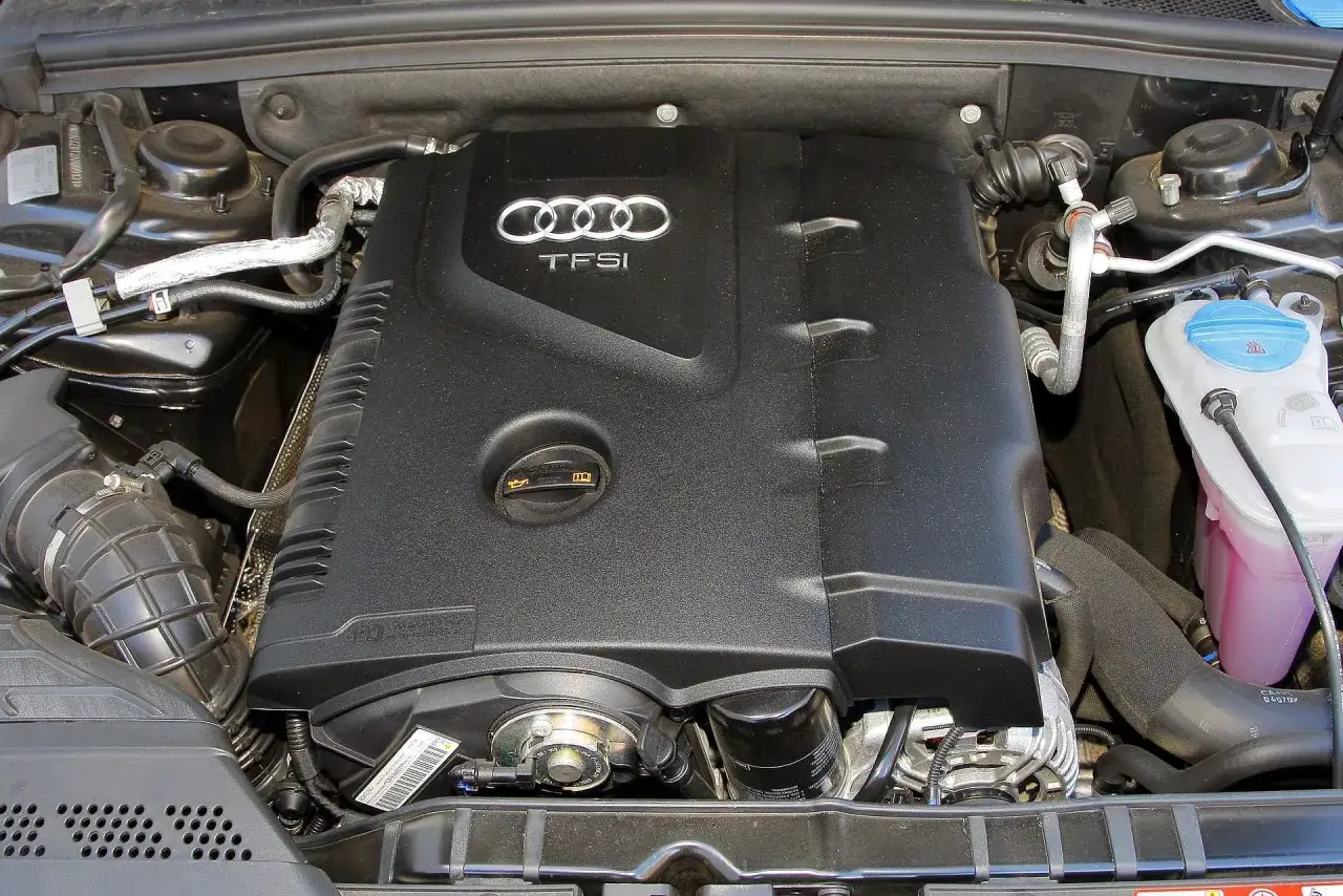 Silnik 2.0 TFSI Audi, czarny, z widocznym logo i elementami układu chłodzenia.