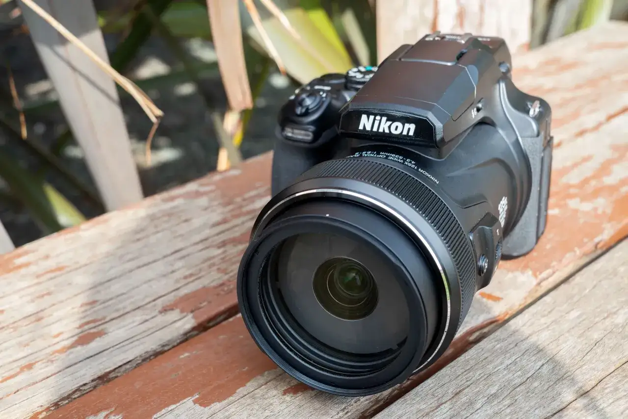 A black Nikon P510 camera rests on a weathered wooden surface, its lens prominent.