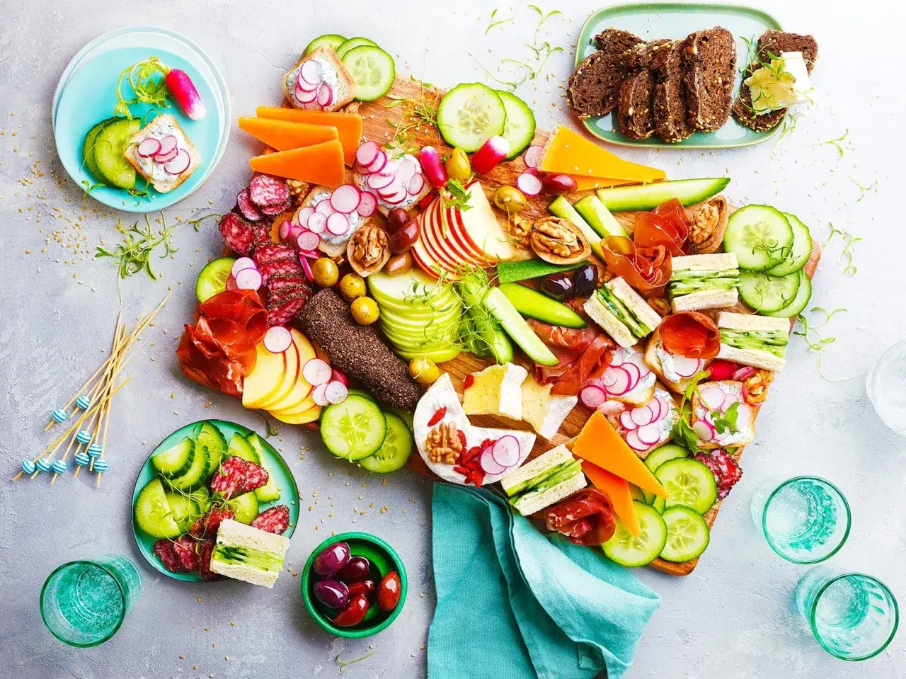 Plateau apéritif coloré : mini sandwichs, charcuterie, fromage, crudités et fruits. Une idée apéro rapide sans cuisson, parfaite pour un repas léger et convivial.